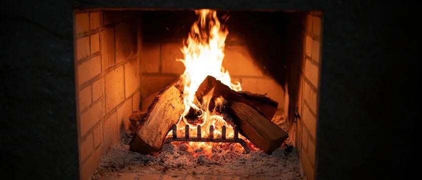 Logs burning brightly inside a masonry firebox