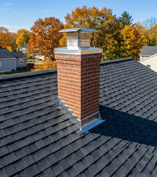 After: bright new brick chimney with stainless cap and fresh step flashing